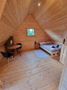 - une chambre avec un lit et une table dans une cabine dans l'établissement Domek w drapie, à Lubomierz