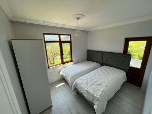 1 Schlafzimmer mit 2 Betten und einem Fenster in der Unterkunft Fanus Cafe Konaklama & Restorant in Düzköy
