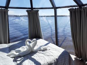 dos cisnes blancos están sentados en una cama en un barco en Laponia Sky Hut, en Gällivare