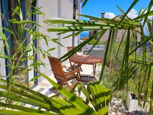 2 Stühle und ein Tisch auf einer Terrasse mit Pflanzen in der Unterkunft Bella Vista Lux Apartment with private Terace in Koper