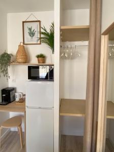 a kitchen with a white refrigerator and a table at Chambre climatisée 2 lits - Proche Centre Tramway in Montpellier