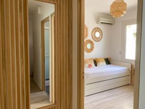 Dormitorio pequeño con cama y espejo en Chambre climatisée 2 lits - Proche Centre Tramway, en Montpellier