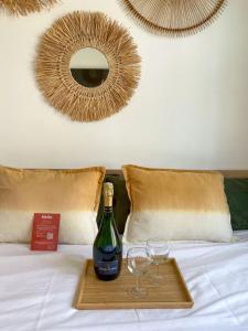 a tray with a bottle of wine and two glasses on a bed at Chambre climatisée 2 lits - Proche Centre Tramway in Montpellier