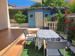 a patio with a table and chairs and a play house at Torredembarra House in Torredembarra