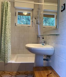a bathroom with a sink and a tub and a shower at Apartment Sersic in Baška