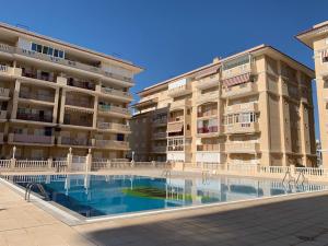 a large apartment building with a swimming pool in front of it at Vista al Mar with Parking Space in La Mata