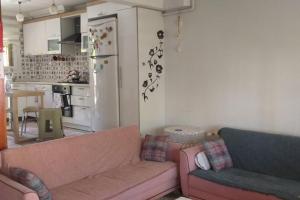 a living room with a pink couch and a kitchen at Near the ladies beach only 200m in Kuşadası
