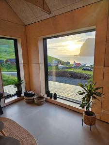 Habitación con ventana grande con vistas al océano. en Kalsoy cottages - Jogvansstova, 