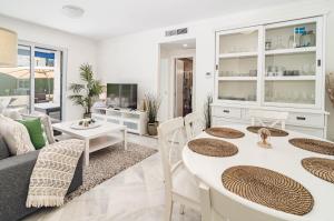 a living room with a couch and a table and chairs at LCR1- Lovely ground floor apartment, Puerto Banus in Marbella