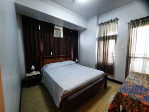 a small bedroom with a bed and a window at Spacious 2BR condo in Araneta Cubao in Manila