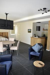 Una sala de estar con mesa y sillas y una cocina. en Den Boomdiek Kats, en Kats