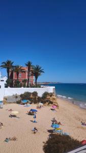 a group of people laying on a beach at Cantinho do Sol - Sea view, Quiet, Cozy and Relaxing Flat in Armação de Pêra