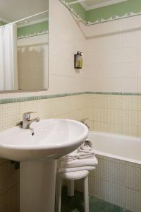 a bathroom with a sink and a bath tub at IRAIPE Ongi Hotel in Oñate