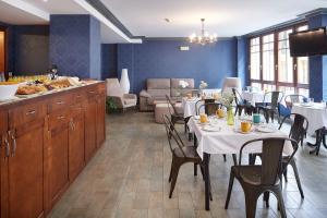 a dining room with tables and chairs and a kitchen at IRAIPE Ongi Hotel in Oñate