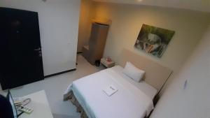 ein Schlafzimmer mit einem weißen Bett in einem Zimmer in der Unterkunft Galaxy Inn in Baubau
