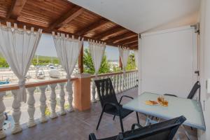 a dining room with a table and chairs on a balcony at Apartment Simunic Punta in Bibinje