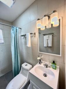 y baño con lavabo, aseo y espejo. en Cozy apartment in Venetian RD within 10min from Airports en Turtle Cove