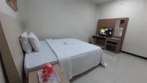 une chambre d'hôtel avec un lit et une télévision dans l'établissement Galaxy Inn, à Baubau