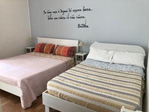 1 dormitorio con 2 camas y una cita en la pared en Villa Viola en Forlì