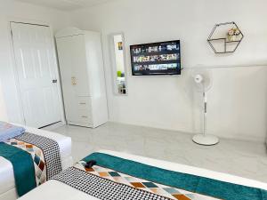 Habitación con cama y TV en la pared. en Cozy apartment in Venetian RD within 10min from Airports en Turtle Cove