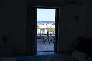 una puerta que da a un balcón con vistas al océano en MIMIS APARTMENTS, en Kefalos