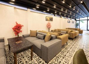 Selia SUİTES في طرابزون: غرفة انتظار مزودة بالأرائك والطاولات والورود