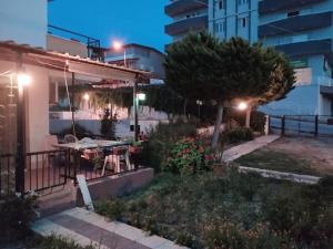 a backyard at night with a table and a tree at Kadınlar den plajına 50 metre bahçeli 1+1 in Kuşadası