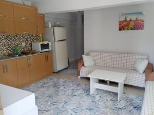 a living room with a couch and a refrigerator at Kadınlar den plajına 50 metre bahçeli 1+1 in Kuşadası