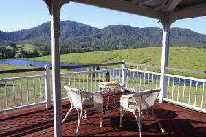 a table and chairs on a porch with a view of a mountain at Cookes Road Cottage at Conondale in Conondale