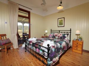 a bedroom with a bed and a chair and a window at Cookes Road Cottage at Conondale in Conondale