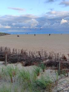 a beach with people on the sand and the ocean at Dreamholia in Jastarnia