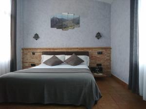 a bedroom with a large bed and two paintings on the wall at Casa Vargas in Pedrezuela