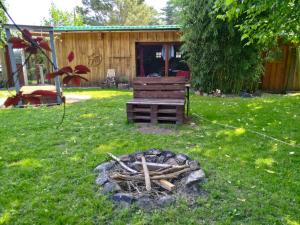 a fire pit in a yard with a bench at Ferienhaus Feuer Wasser Luft Erde in Dobbrikow +5 photos