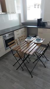 une cuisine avec une table en bois et deux chaises dans l'établissement Monteurszimmer in Hof, à Hof