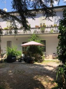a white house with an umbrella in the yard at Villa Viola in Forlì