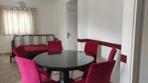 a dining room with a table and pink chairs at Apartments Mazuran in Hvar