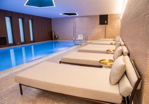 a row of beds in front of a pool at Theatron Jerusalem Hotel & Spa - MGallery Collection in Jerusalem