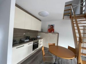 una pequeña cocina con una mesa de madera y una escalera en Apartmán z wellnes, en Bratislava