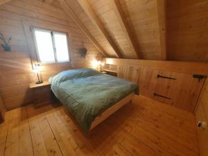 a bedroom with a bed in a wooden room at La Mazzonette - 4* chalet in de natuur met hottub in Dommartin-lès-Remiremont
