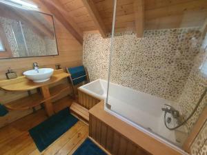 a bathroom with a bath tub and a sink at La Mazzonette - 4* chalet in de natuur met hottub in Dommartin-lès-Remiremont