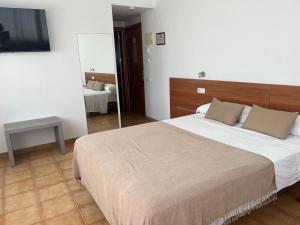 1 dormitorio con 1 cama grande y espejo en Vehí, en Cadaqués