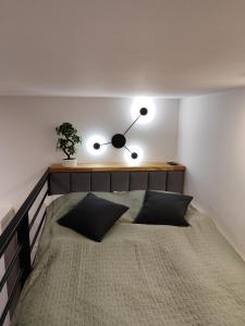 ein Schlafzimmer mit einem Bett mit einer Uhr an der Wand in der Unterkunft Apartament Narutowicza 56 in Łódź