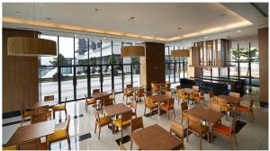 a restaurant with wooden tables and chairs and windows at The Elements service apartment, Jalan Ampang in Kuala Lumpur