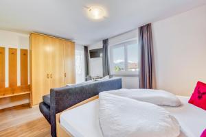 ナトゥルノにあるGarni Schmiedhofのベッドルーム1室(ベッド1台、ソファ、窓付)