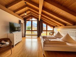 um quarto com uma cama e uma televisão e algumas janelas em Ferienhaus Sissi em Schwangau