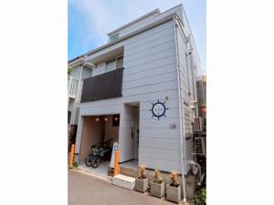 藤澤的住宿－Enoshima Guest House 134 / Vacation STAY 47419，白色的建筑,旁边有一个钟