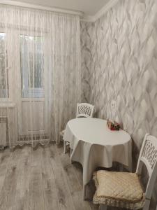 una sala da pranzo con un tavolo e due sedie di Квартира в городе Хромтау a Khromtaū