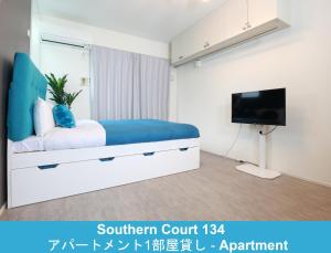 a bedroom with a bed and a tv at Enoshima Guest House 134 / Vacation STAY 60850 in Fujisawa