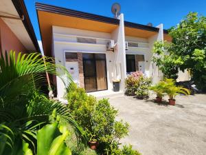 TalibonCAP Apartments的前面有植物的房子