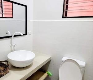 a bathroom with a white sink and a toilet at CAP Apartments in Talibon